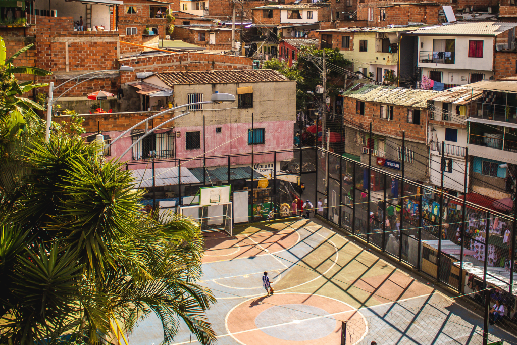 Favela com quadra de esporte para representar um investimento social que crie condições esportivas para a população em situação de vulnerabilidade social.